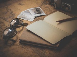 Few polaroids, a camera, glasses and a notebook